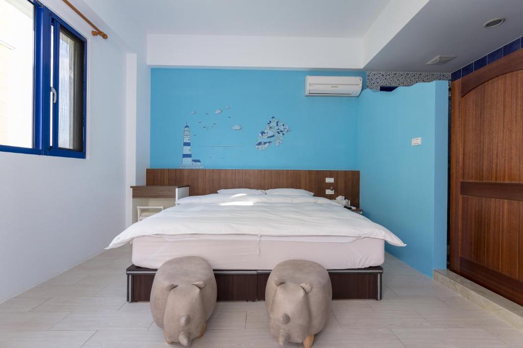 a bedroom with a large bed with two elephant heads on the floor at Travel Light House in Magong
