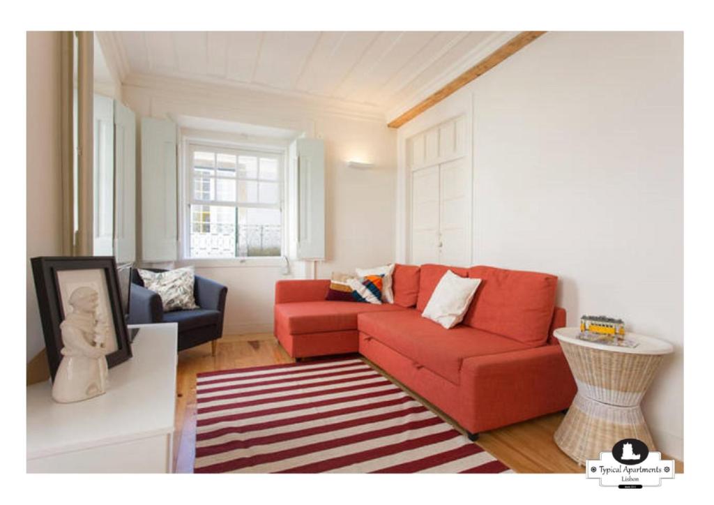 リスボンにあるSupimpa Typical Apartmentのリビングルーム(赤いソファ、椅子2脚付)