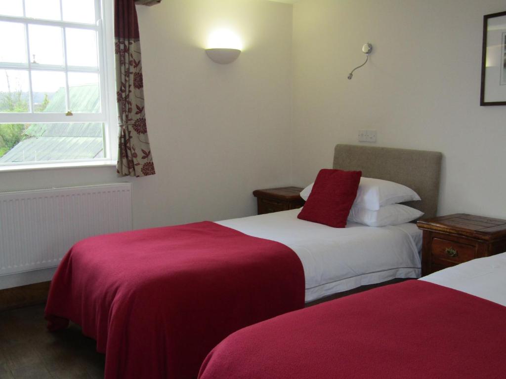 a hotel room with two beds and a window at The Kilcot Inn in Newent