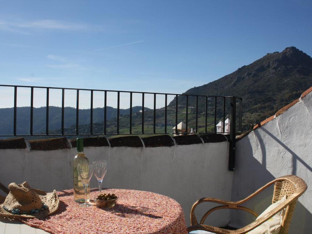 una mesa con una botella y vasos en el balcón en Casa Nina, en Gaucín