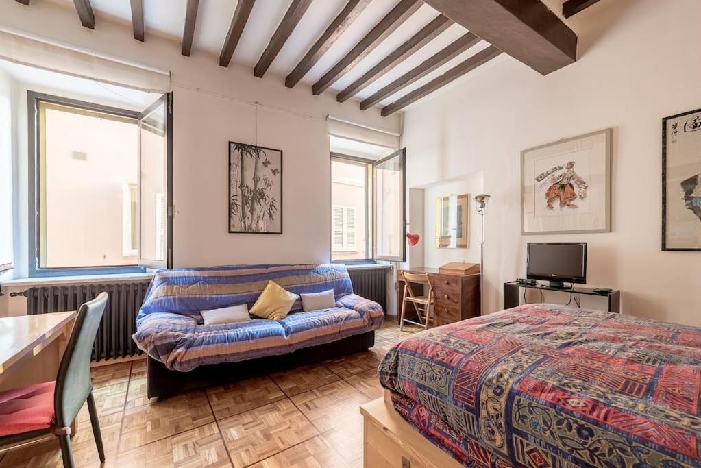 - une chambre avec un lit et un canapé dans l'établissement Studio Borgo Colonne, à Parme