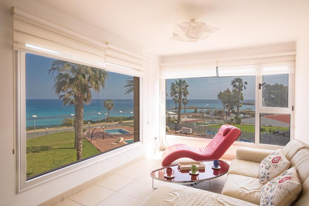 a living room with a view of the ocean at Pallinio Fig Tree Bay Apartments in Protaras