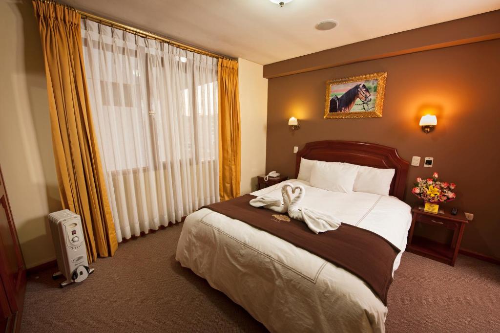 Una habitación de hotel con una cama con una toalla. en Hotel Mabey Cusco, en Cusco