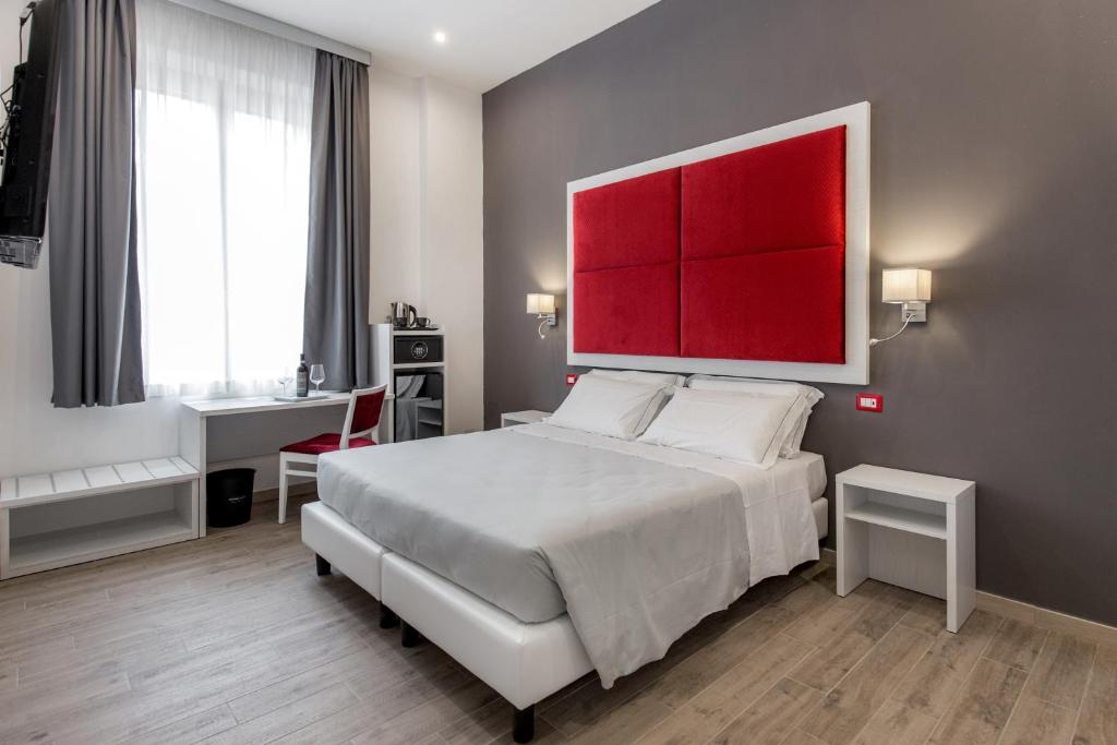 una camera con un grande letto con testiera rossa di Apollo Guest House a Firenze