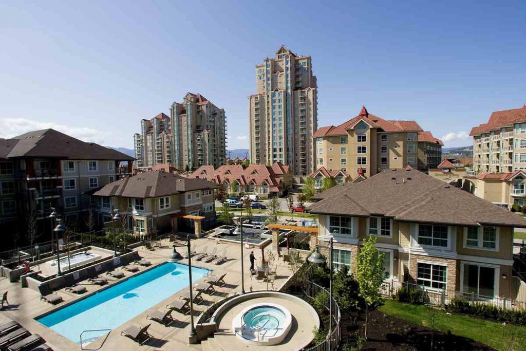 an apartment complex with a swimming pool and buildings at Waterscape - Downtown Kelowna in Kelowna