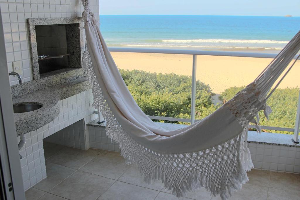 uma rede de descanso na casa de banho com vista para a praia em Aquarelle Ingleses em Florianópolis