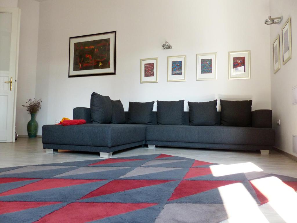 a living room with a blue couch and a rug at Apartment 43 in Budapest