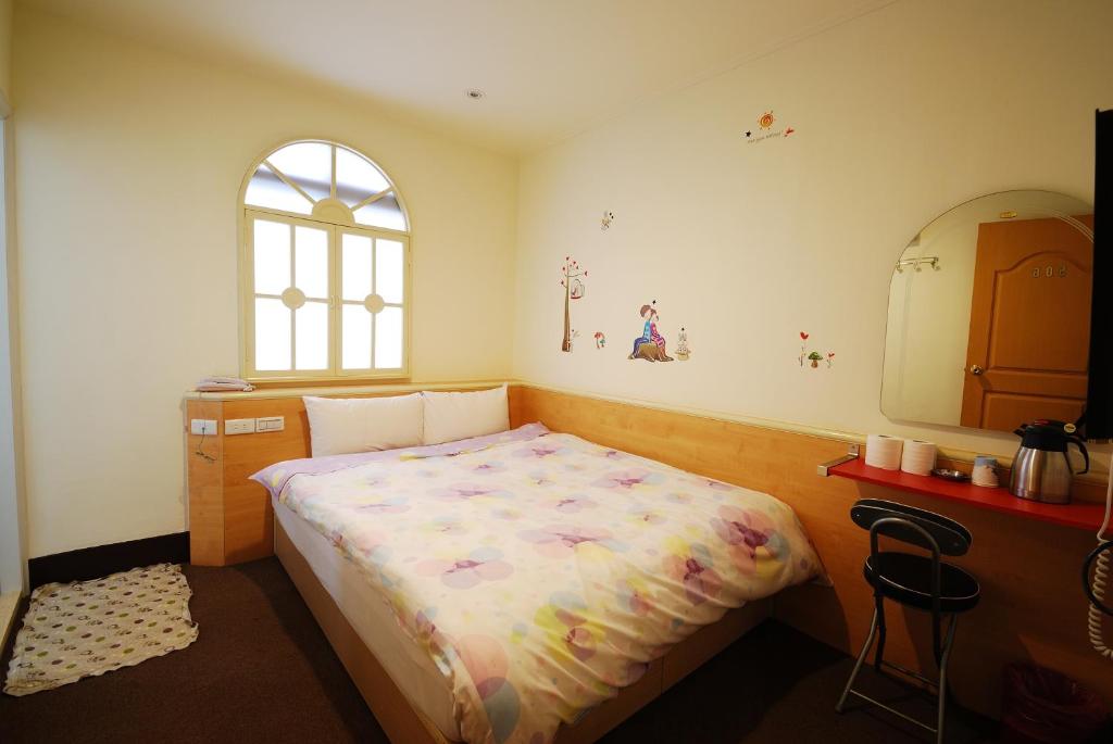 ein Schlafzimmer mit einem Bett, einer Kommode und einem Fenster in der Unterkunft Sun Ho Inn in Taipeh