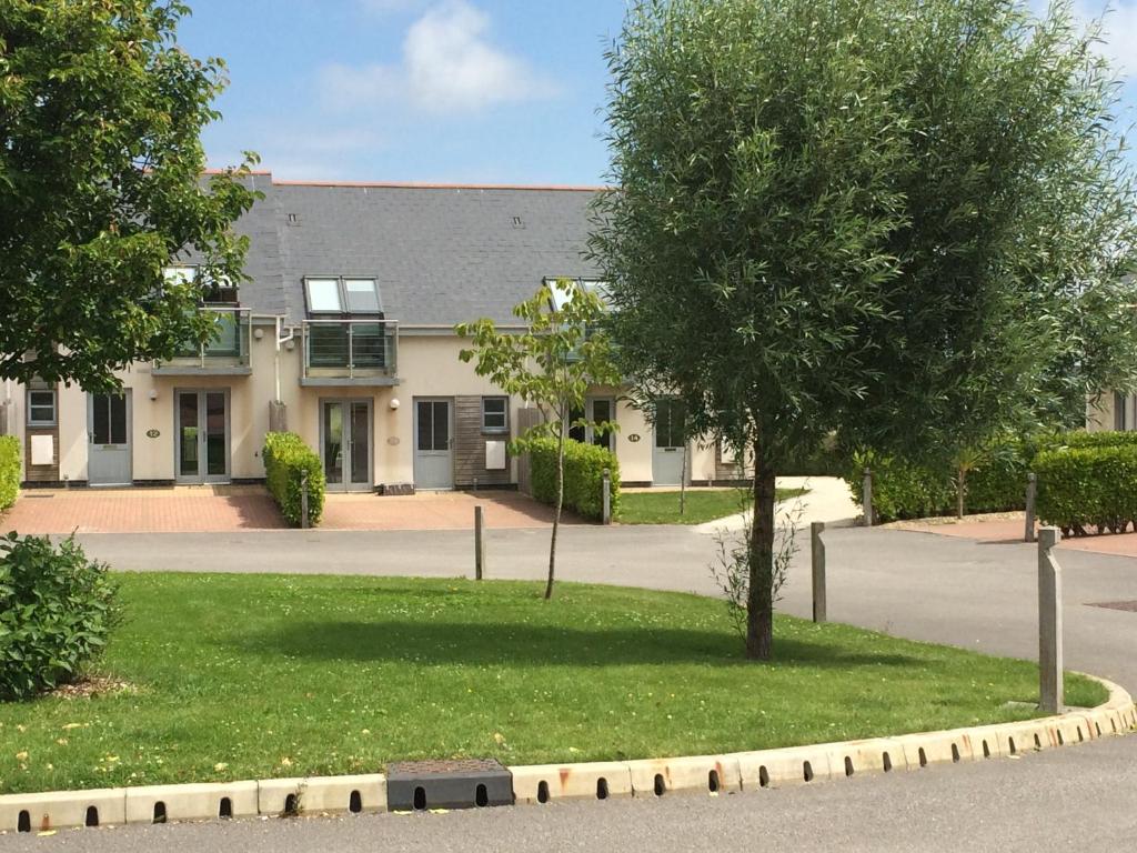 a building with a tree in front of it at Bay Retreat Villas in Padstow