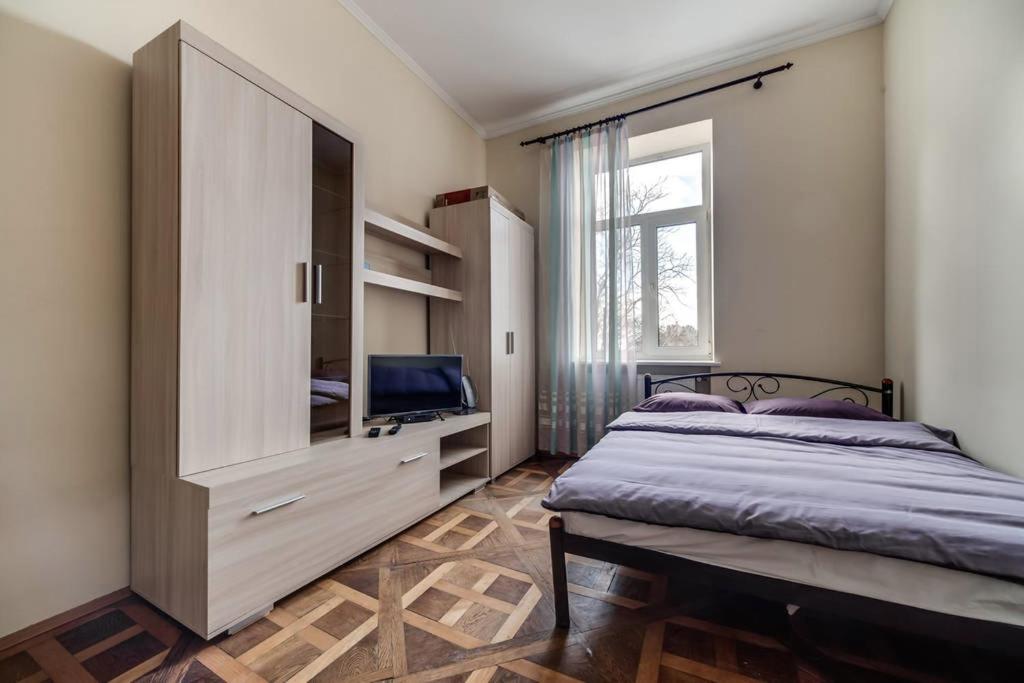 um quarto com uma cama, uma cómoda e uma janela em Apartment on Lysenka 27 em Lviv