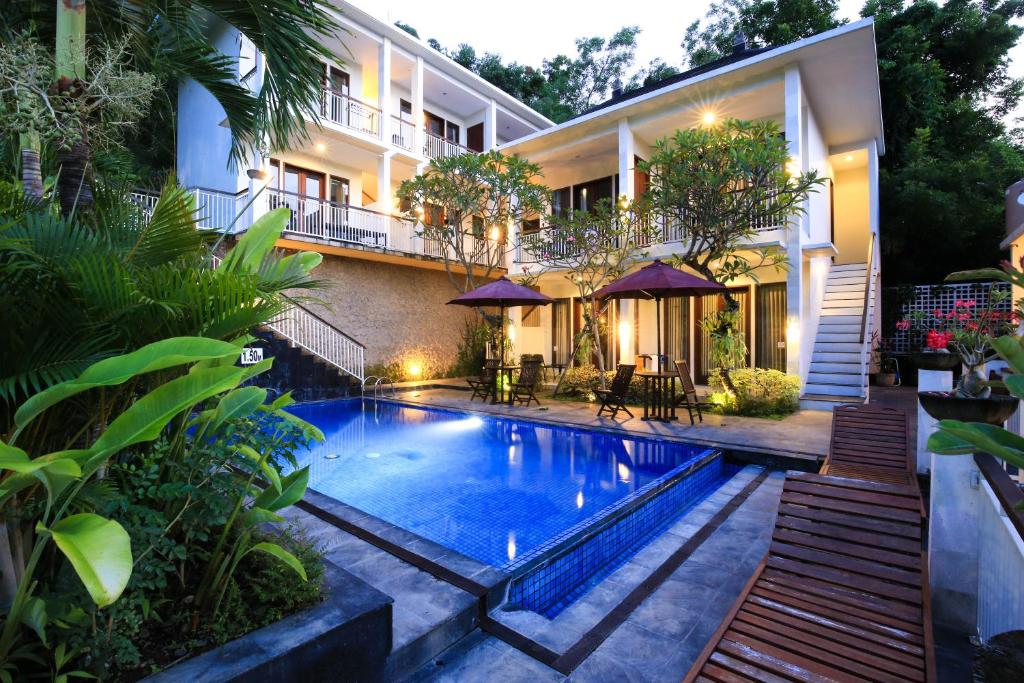 a swimming pool in front of a house at Dewi Villa in Padangbai