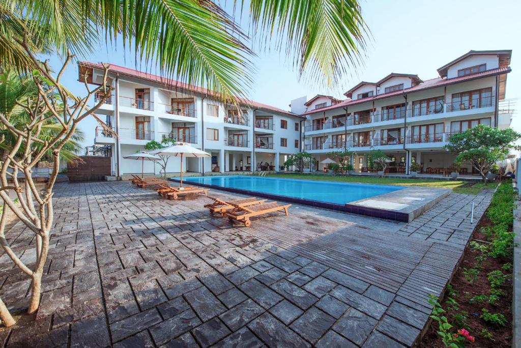 um hotel com piscina e um resort em Cardamon Hotel Nilaveli em Nilaveli