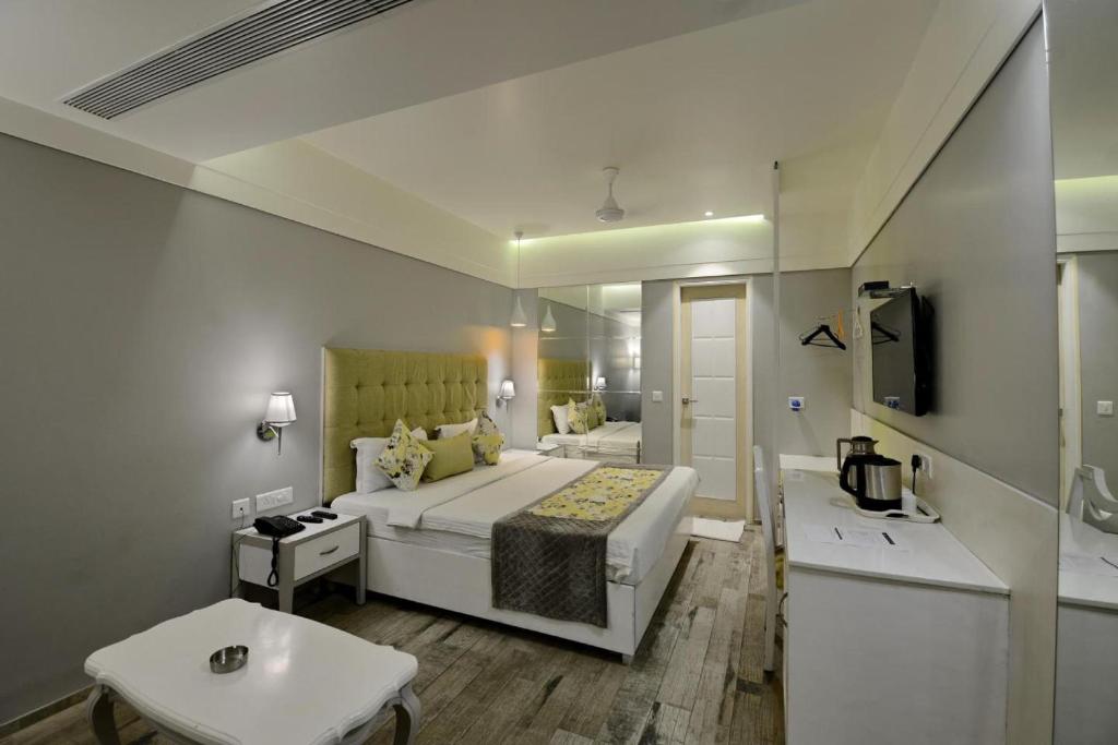 1 dormitorio con 1 cama grande y baño en Hotel Emerald, en Chandīgarh