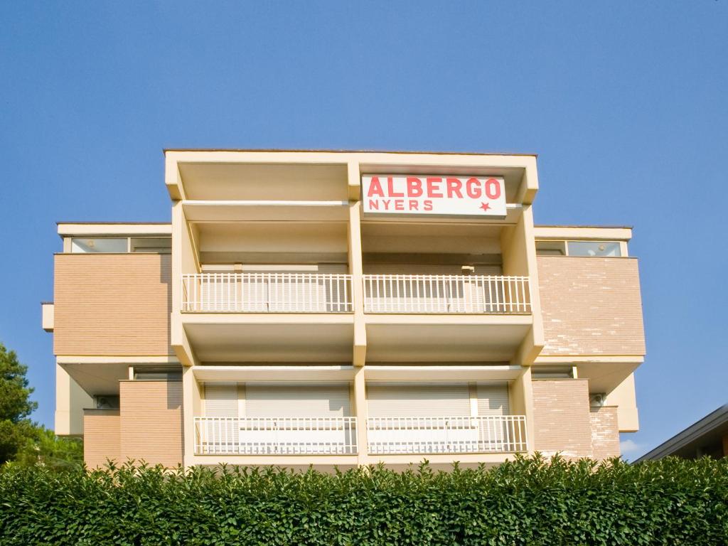 un gran edificio de apartamentos con un signo albergo mens en Albergo Nyers en Perugia