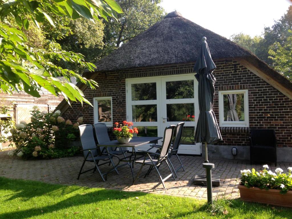 une terrasse avec une table, des chaises et un parasol dans l'établissement Op de Kuyerlatten, à Zwolle