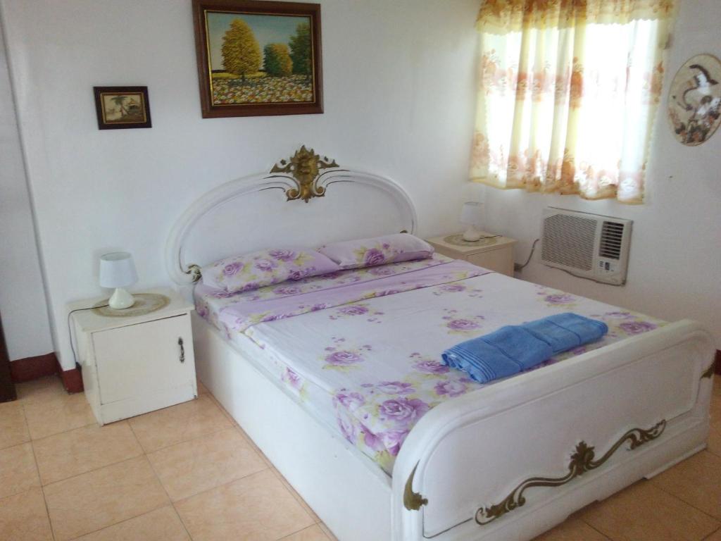 Un dormitorio con una cama blanca con flores. en White Castle Hotel and Resort, en Balibago