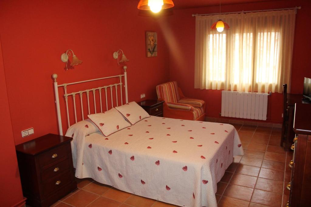 a bedroom with a bed in a red room at Alojamiento Rural Sierra Luz in Ribatajadilla