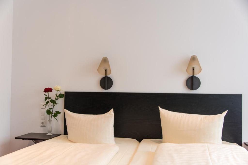 a bedroom with a bed with two lamps above it at Hotel Fürstenhof in Braunschweig