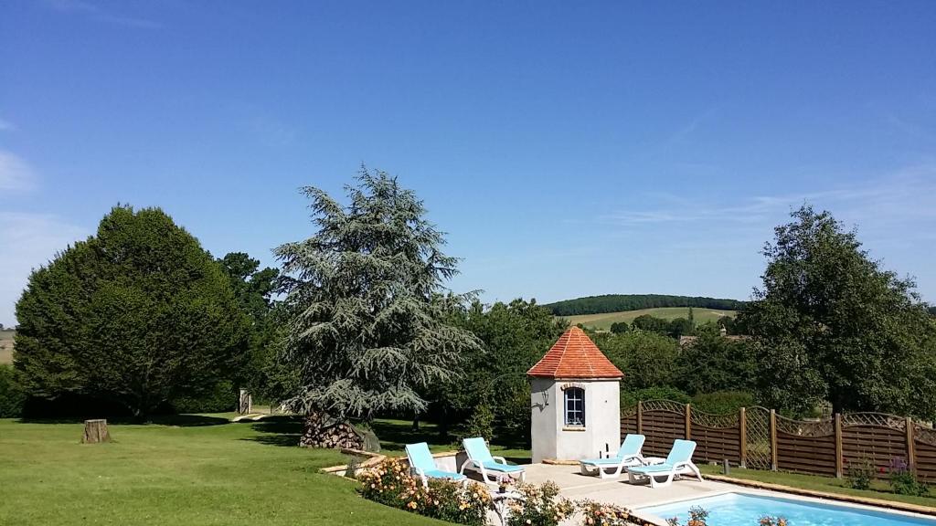 a swimming pool with chairs and a small house at La Cle des Champs in Provency