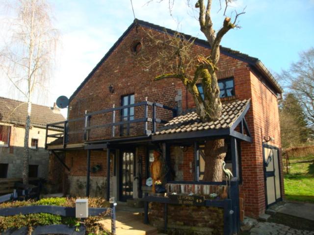 a brick house with a tree on top of it at Le poirier de Warre in Durbuy