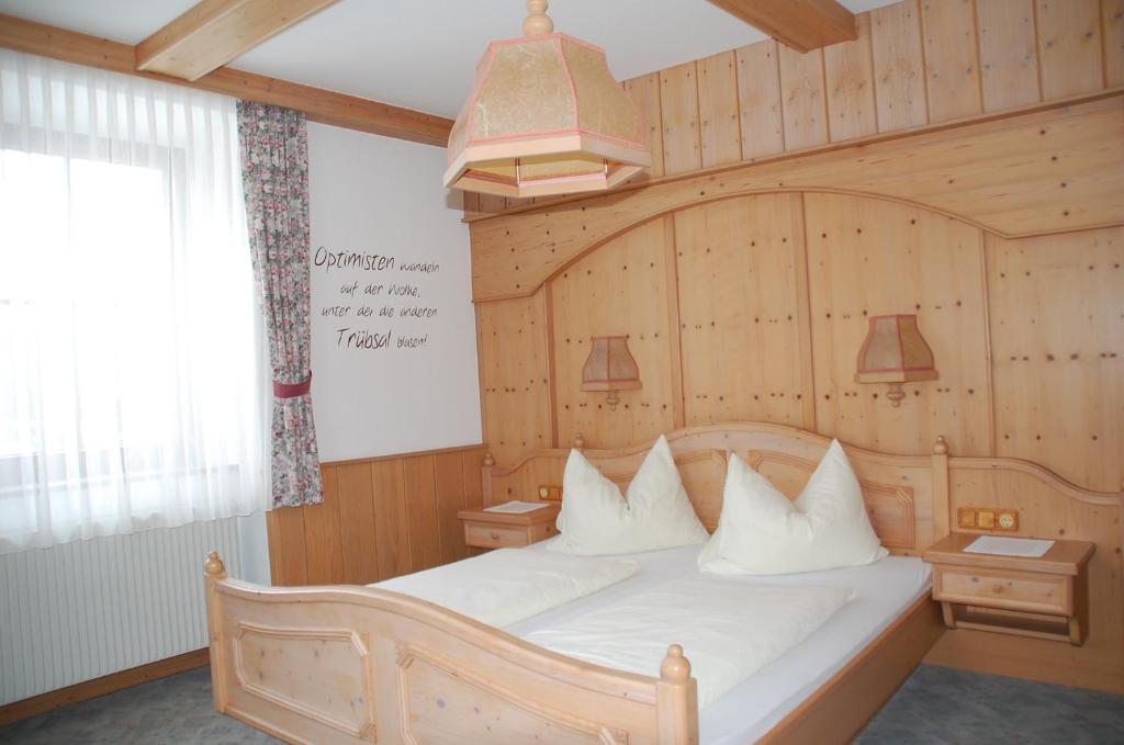 a bedroom with a large bed with white pillows at Gasthof Rüscher in Donnersbach