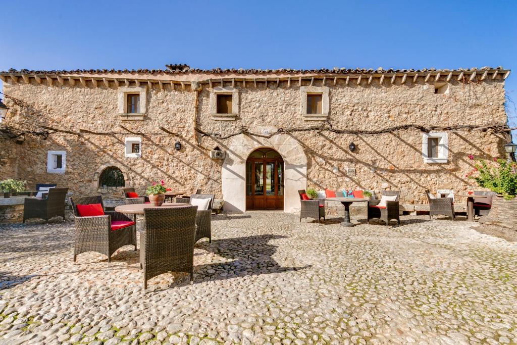 um edifício de pedra com mesas e cadeiras em frente em Agroturisme Son Pons em Búger