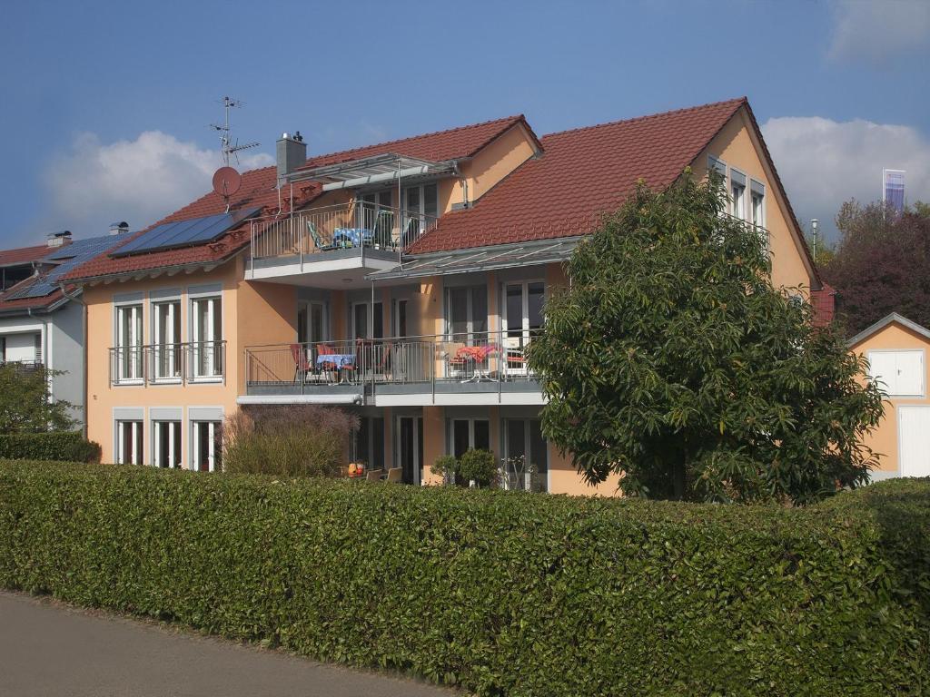 een groot huis met een boom ervoor bij Haus Hartmann, Ferienwohnungen Sonnenseite in Wasserburg