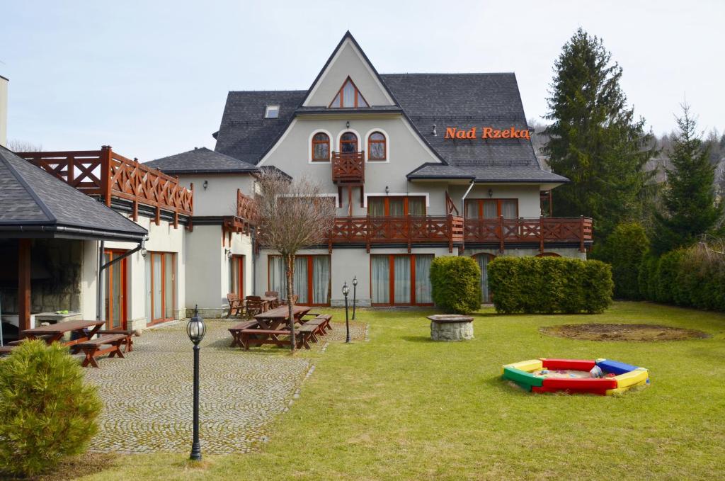 Casa blanca grande con patio con piscina en Poduszka Pensjonat Nad Rzeką, en Wisła