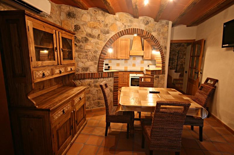 a kitchen with a table and chairs in a room at Casa Rural Cal Puyo in Paúls
