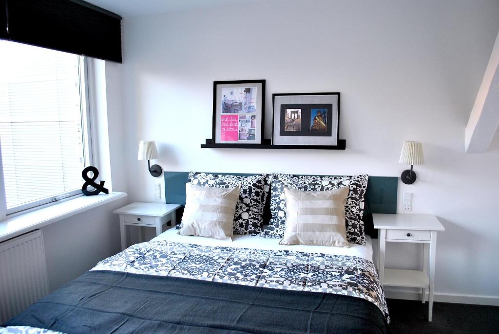 1 dormitorio con cama con almohadas y ventana en M18 en Copenhague