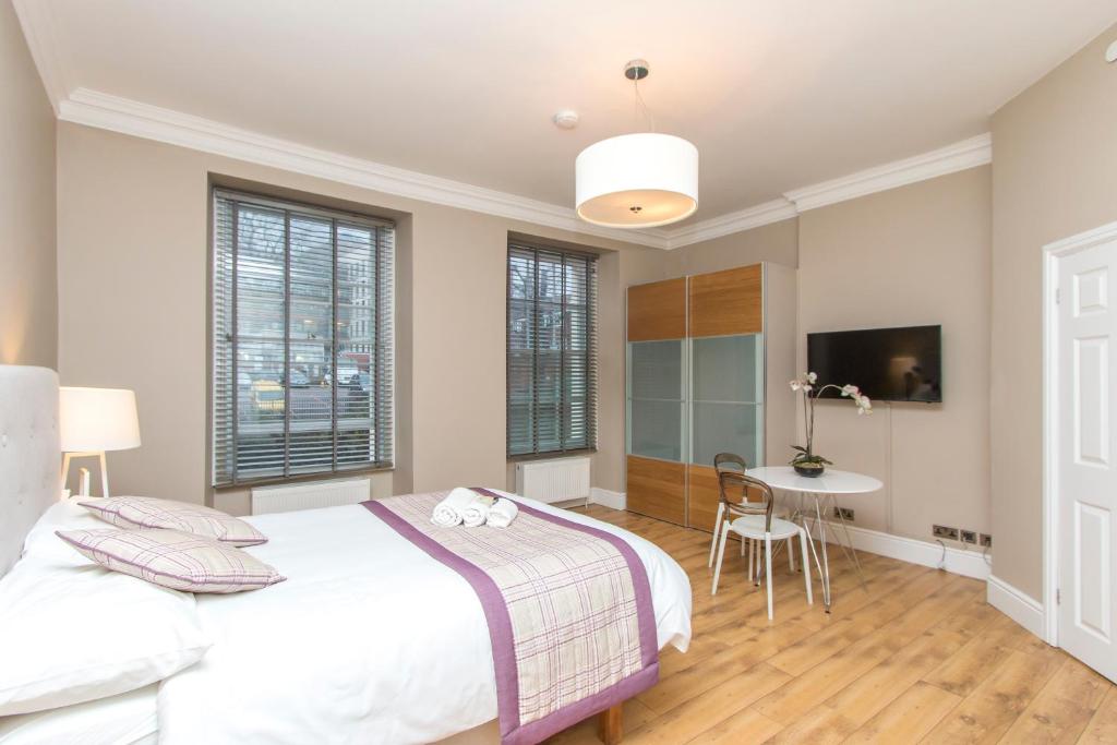 a bedroom with a large bed and a table at Number 1 Park Apartments in Bristol