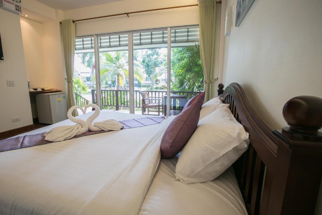 a bedroom with a bed with swans towels on it at Nisasiri Boutique Resort in Laem Sing