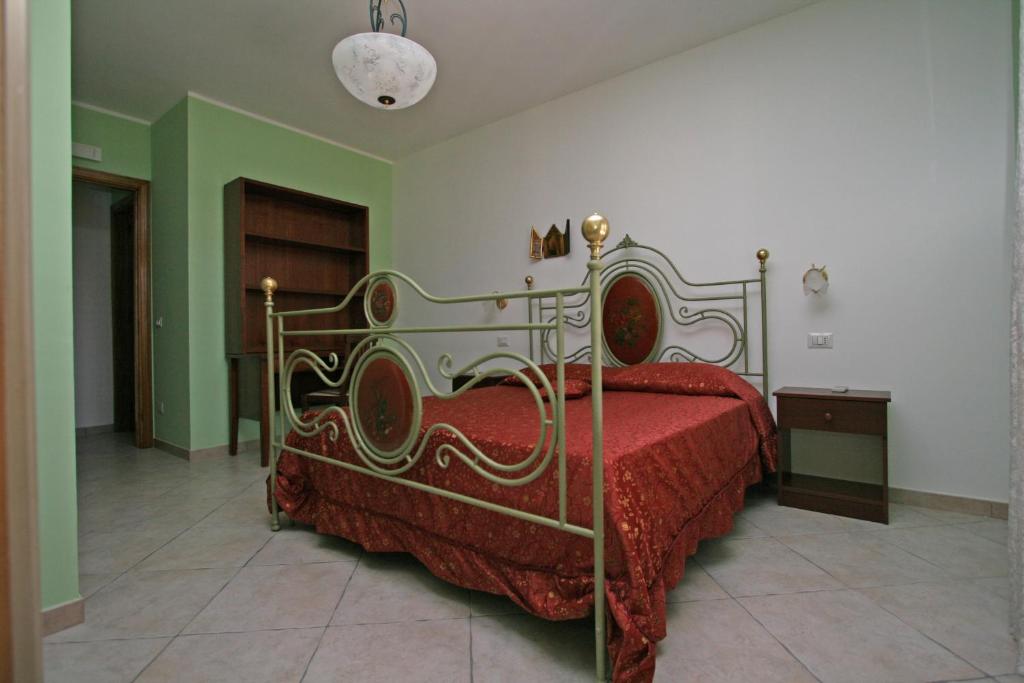 サン・ヴィート・ロ・カーポにあるAppartamento Armonie Verdeのベッドルーム1室(赤いベッドカバー付)
