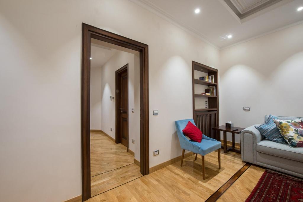 a room with a couch and a chair and a mirror at 900 Apartments in Rome