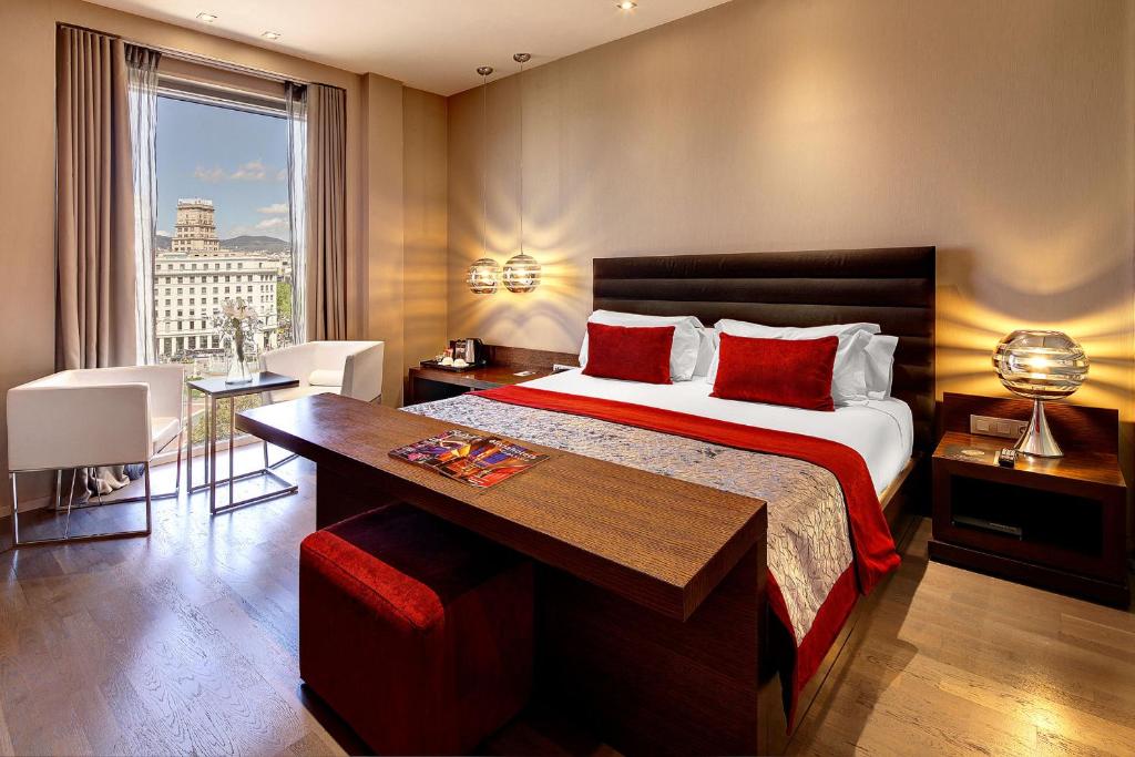 um quarto com uma cama, uma secretária e uma janela em Olivia Plaza Hotel em Barcelona