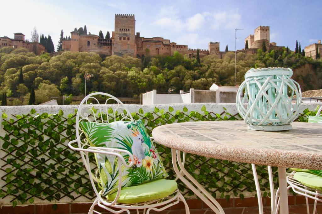 a table and chairs with a view of a castle at Apartamentos Inside Paseo de los Tristes in Granada
