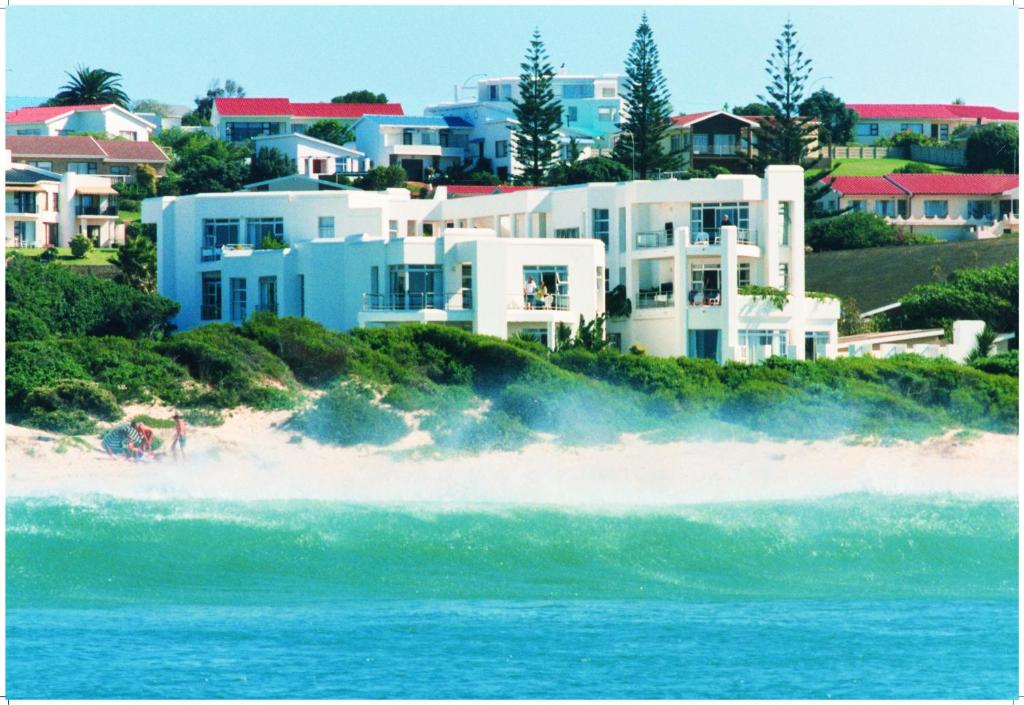 a large house on a beach next to the ocean at Diaz 15 House on the Bay in Jeffreys Bay