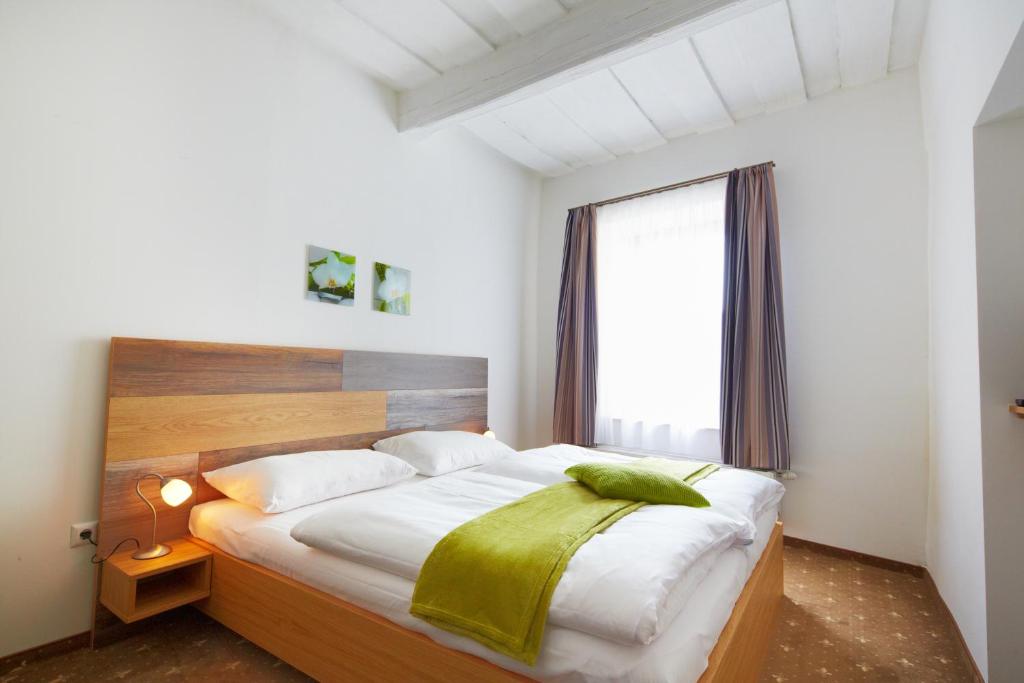 
a bed in a room with a white bedspread at Rathauskeller Melk in Melk
