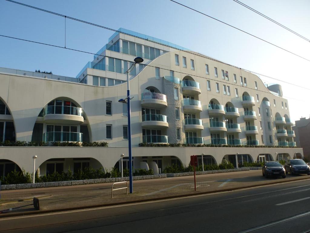un edificio al lado de una calle con coches aparcados delante en White Princess - Lehouck, en Koksijde