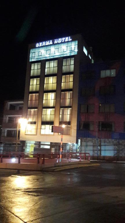 a building with a sign on top of it at night at Apart Serma Hotel in Potosí