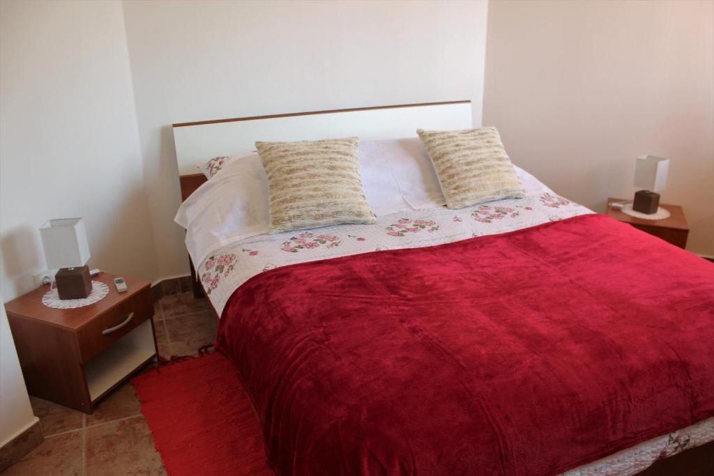 a bedroom with a large bed with a red blanket at Apartment MIS Floura in Rijeka
