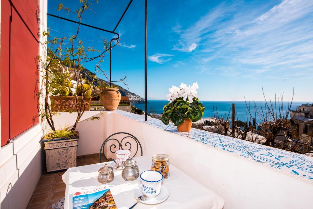 a table on a balcony with a view of the ocean at Dimora del Podestà in Positano