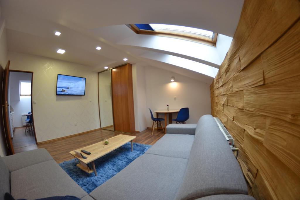 a living room with a couch and a table at Apartament City Center Sky in Krynica Zdrój
