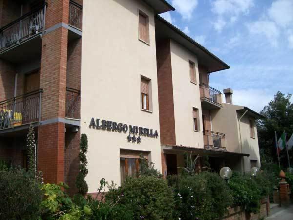 an apartment building with a sign on the side of it at Hotel Mirella in Castiglione della Pescaia