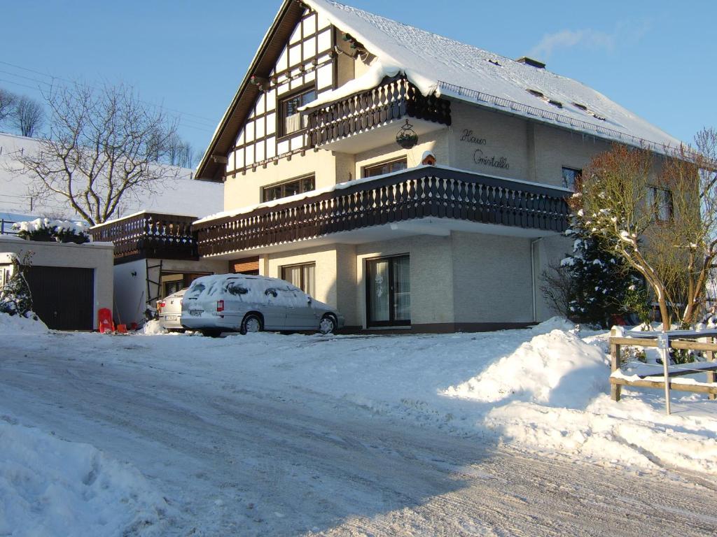 オルスベルクにあるHaus Cristalloの雪に停められた車を持つ家