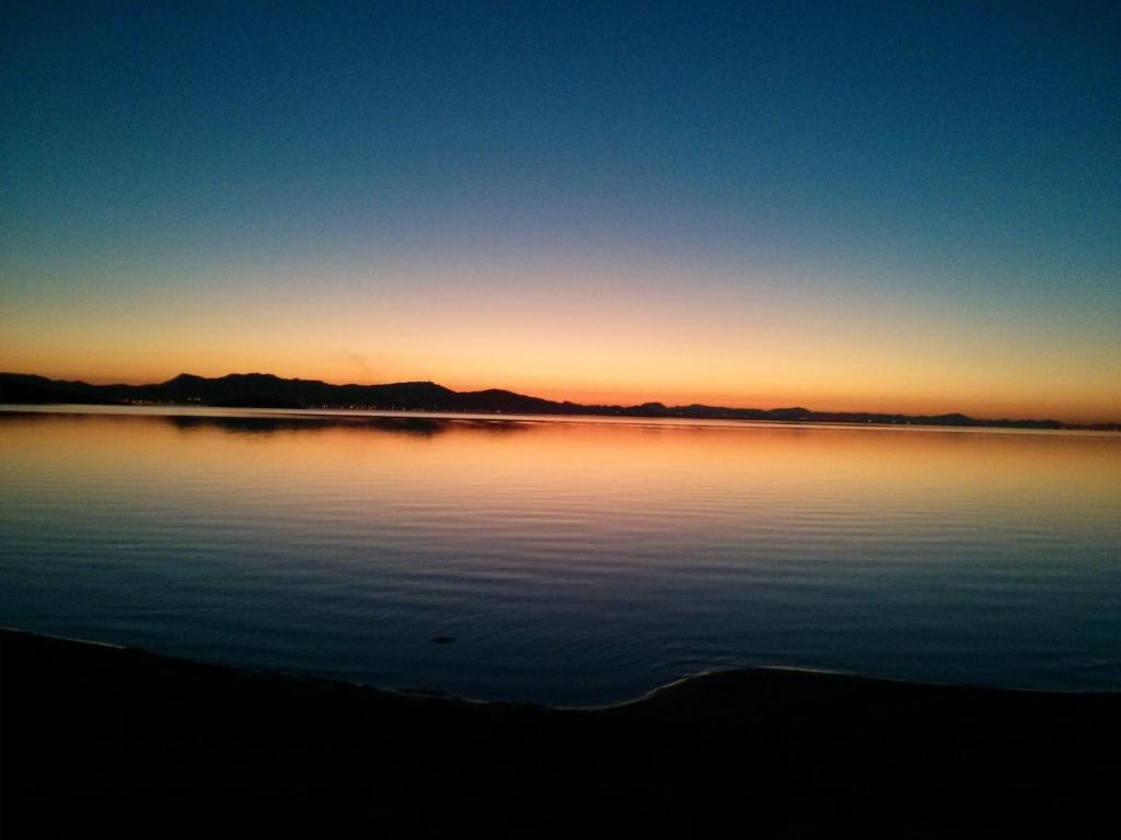 una puesta de sol sobre un gran cuerpo de agua en Chalecito, en La Manga del Mar Menor