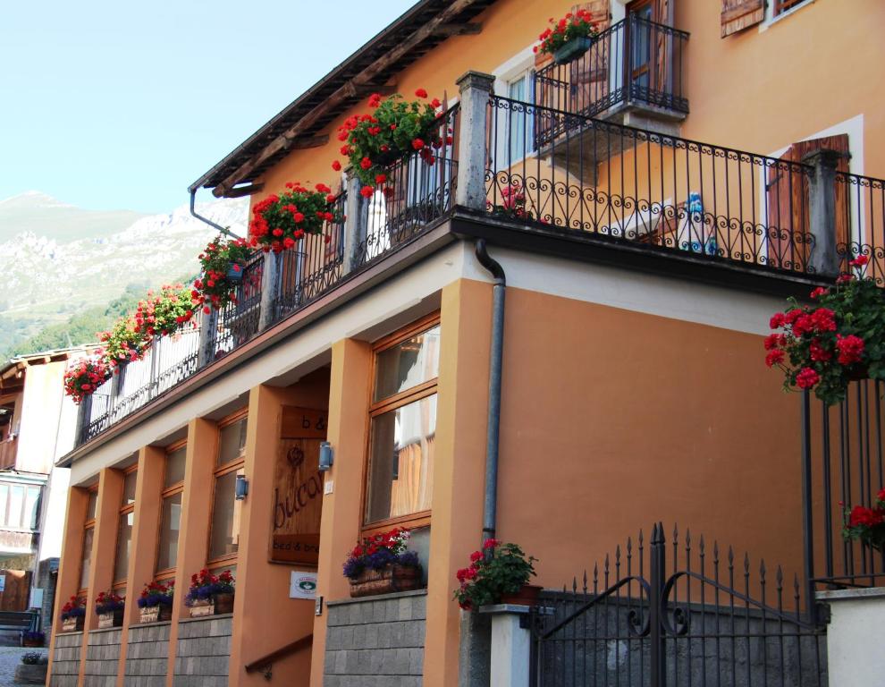 un edificio con macetas de flores en sus balcones en B&B Il Bucaneve en Crissolo