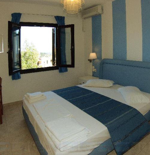 a blue and white bedroom with a large bed at Perla Apartments in Agia Pelagia