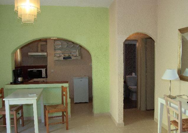 a kitchen and dining room with a table and chairs at Perla Apartments in Agia Pelagia