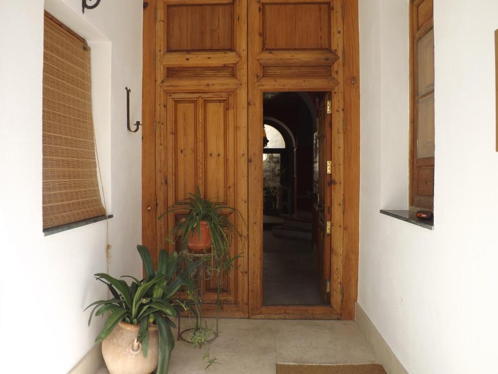 una puerta de madera en una habitación con una planta en Casa Virginia, en Altea